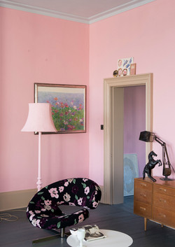Salon rose avec mobilier et éclairage décoratif
